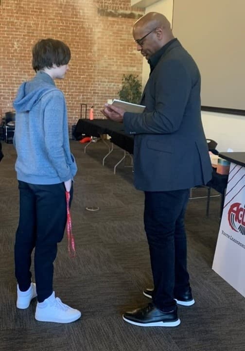 Eric Swann presenting a book to a young student.