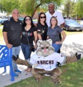 Eric Swann posing with a sports mascot and event guests.